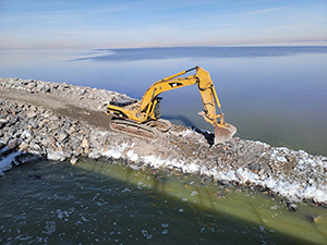 Excavator raising the great salt lake causeway berm