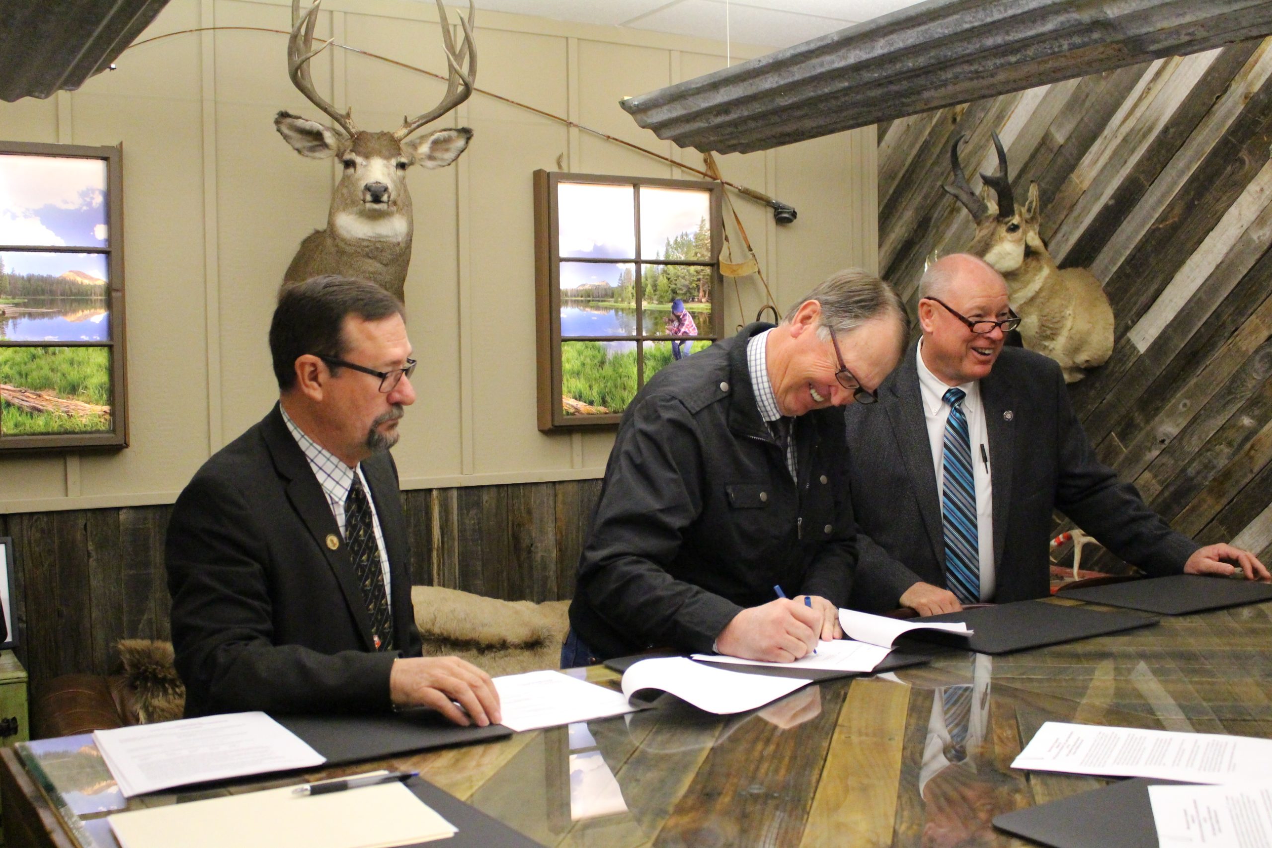 Government officials in a lodge signing the hunter access agreement