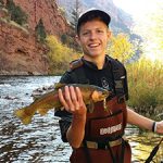 Young man holding rainbow trout caught at Flaming Gorge